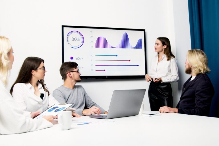 Eine Frau hält eine PowerPoint-Präsentation und versucht dabei auf den Punkt zu kommunizieren.