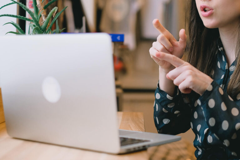Eine Frau hält online eine PowerPoint Präsentation vorm Laptop nach Pyramidenprinzip