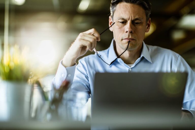 Ein Mann sitzt am Laptop und sieht besorgt aus. Ist er eine mittelmäßige Führungskraft?